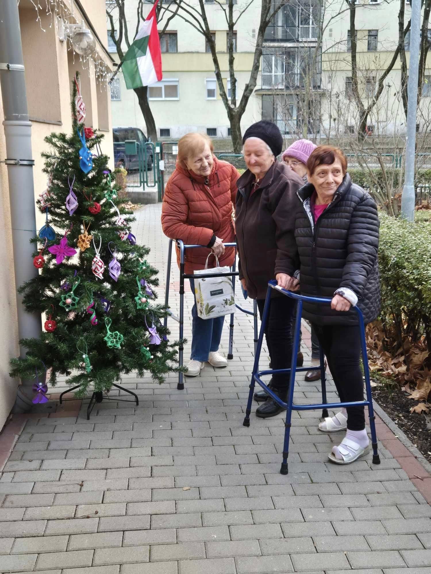 Lakók és az általuk készített díszekkel ékesített fa